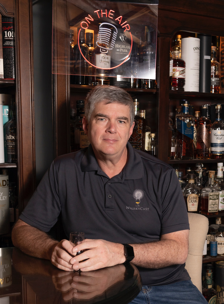 Mark Gillespie surrounded by whiskey bottles